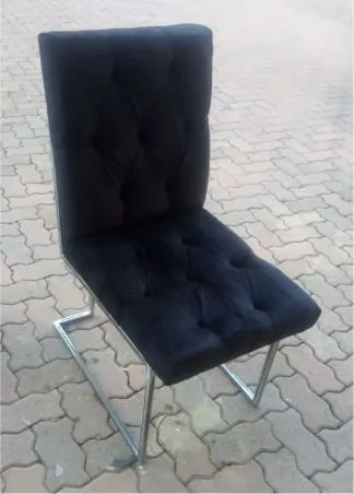Finished bar stool with a buttoned black velvet seat and back on a polished stainless cantilever frame